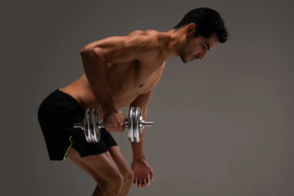 Side view of determined Hispanic young man doing back workout