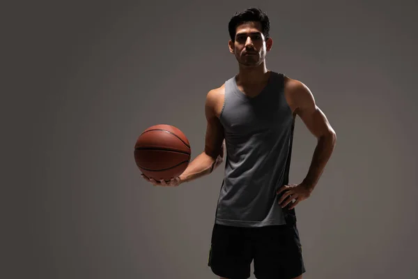 英俊的拉丁年轻男子篮球运动员 背景灰暗 — 图库照片