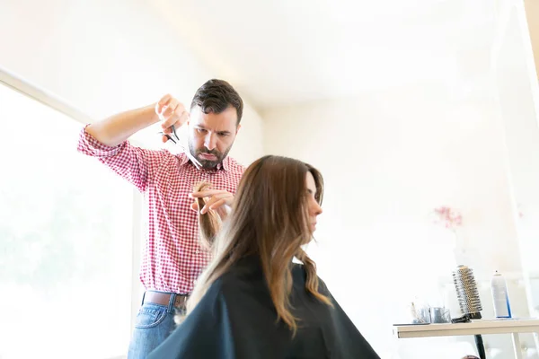 ヒスパニック男性美容師カッティング髪の女性クライアントに美容室 — ストック写真