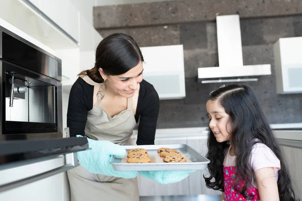 Latinská Matka Ukazuje Čerstvě Upečené Sušenky Dceři Kuchyni — Stock fotografie