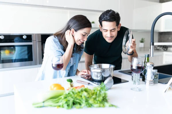 Casal Jovem Hispânico Cheirando Comida Enquanto Cozinha Casa — Fotografia de Stock