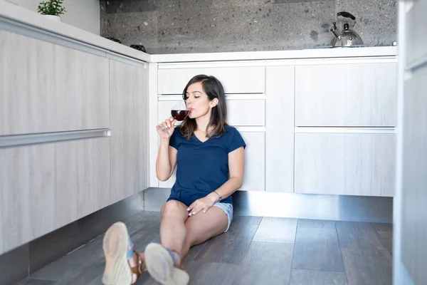 Latina Donna Attraente Bere Vino Mentre Seduto Sul Pavimento Cucina — Foto Stock