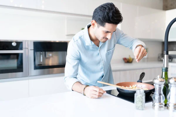 Hübscher Junger Mann Streut Kraut Während Hause Pasta Zubereitet — Stockfoto