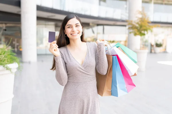 Lächelnde Attraktive Lateinerin Zeigt Kreditkarte Während Sie Vor Einem Einkaufszentrum — Stockfoto