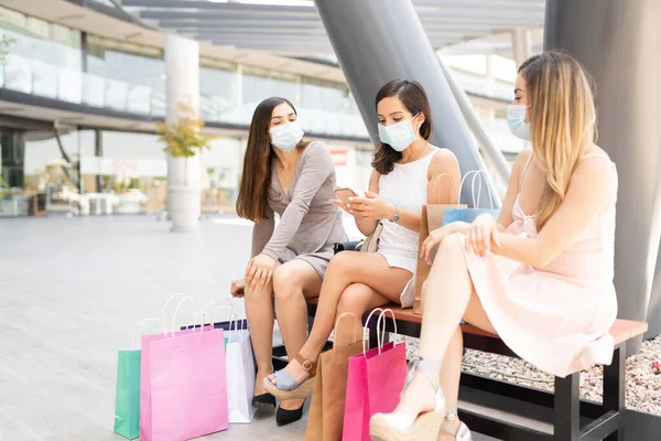 Vrouwelijke Vrienden Dragen Gezichtsmaskers Terwijl Bank Het Winkelcentrum Zitten — Stockfoto