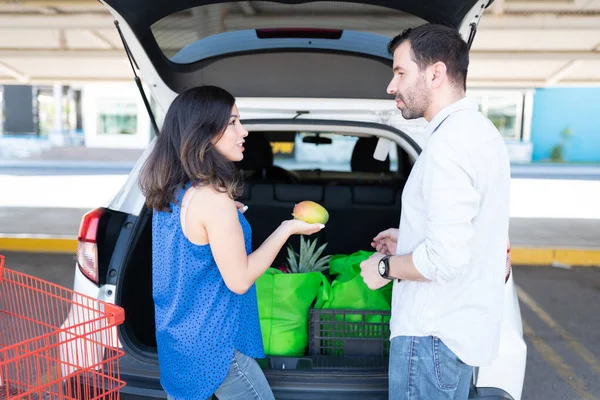 Woman Holding Mango Talking Boyfriend While Standing Car Trunk Parking — Stock Photo, Image