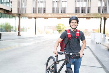 Sokakta bisikletle dolaşan yakışıklı teslimatçı.