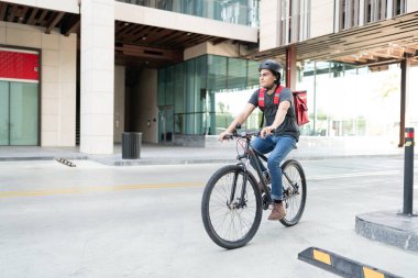 Şehirde bisiklet süren İspanyol bir teslimatçı.