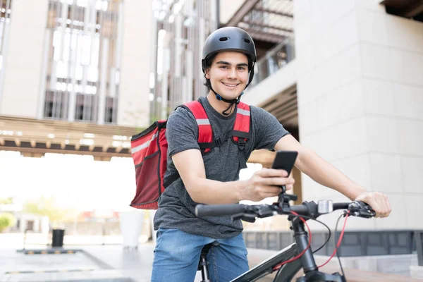 Retrato Homem Entrega Courier Sorrindo Usando Smartphone Bicicleta — Fotografia de Stock
