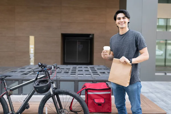 Sorrindo Latino Entrega Homem Segurando Parcela Copo Café Descartável — Fotografia de Stock