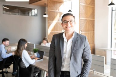 Kafkasyalı başarılı iş adamının portresi. Arka planda çalışan meslektaşlarıyla birlikte.