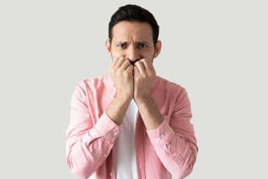 Sıradan kıyafetler giyen ve stüdyoda gergin hissederken tırnaklarını yiyen İspanyol bir adam.