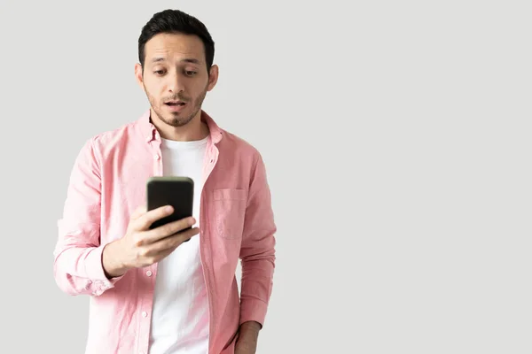 Homem Hispânico Sério Olhando Para Seu Smartphone Com Uma Expressão — Fotografia de Stock