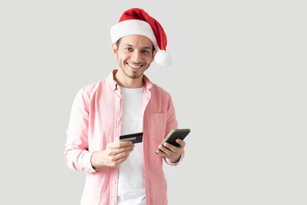 Noel Şapkalı Mutlu Bir Gencin Portresi Kredi Kartı Akıllı Telefonla — Stok fotoğraf