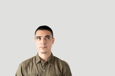 Latin genç adam kopyalama alanına bakıyor ve düşüncelerini ve fikirlerini düzenlemeye çalışıyor ve ilham arıyor.