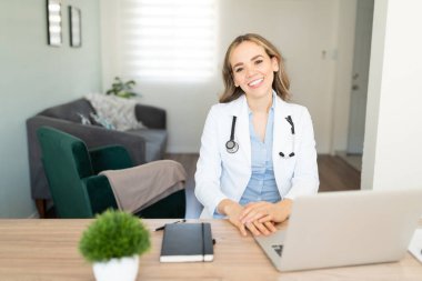 Güzel bayan doktor video aracılığıyla hastalarını bekliyor. Büyük bir gülümseme ve dostça bir tavırla.