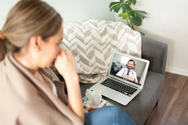 男医生在电脑上通过视频通话给妇女提供医疗建议的情况下的行为 — 图库照片