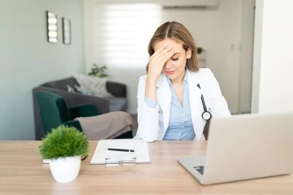 Doctora Tocándose Frente Luciendo Estresada Abrumada Mientras Hace Algunos Trámites —  Fotos de Stock