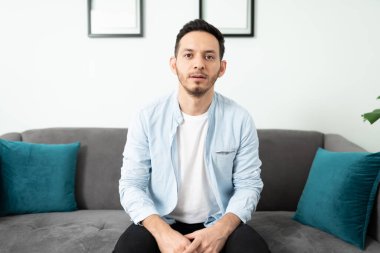 Genç ve yakışıklı bir Latin adamın video çağrısı sırasında ekrana baktığı ekran görüntüsü.