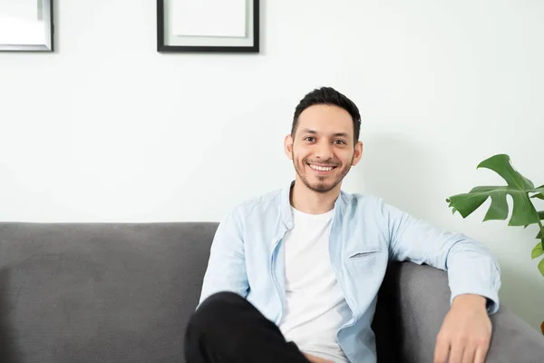 Joven Hombre Latino Sonriente Sentado Sofá Nuevo Apartamento Sala Estar — Foto de Stock