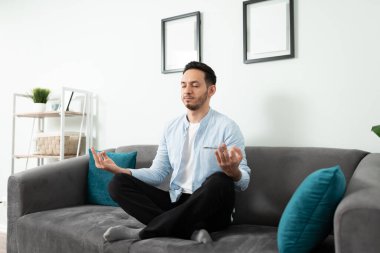 30 'lu yaşlarında bir Latin' in portresi. Meditasyon yapıyor ve gözleri kapalı, huzurlu görünüyor.