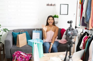 Etkileyici güzel bir kadının portresi merhaba diyor ve moda vlog 'u yaparken takipçilerini selamlıyor.