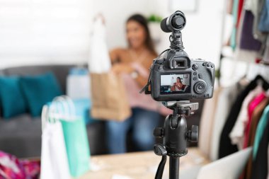 Takipçilerine kıyafetlerini gösterirken bir moda blogcusunu kaydeden bir DSR kamerasının yakın çekimi.
