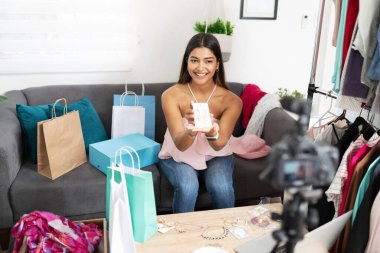 Happy moda blogcusu ve sözü geçen kişi, bir video blogu kaydederken izleyicilerine bazı aksesuarları gösteriyor
