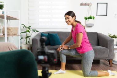 Çevrimiçi kurs için aktif kadın çalıştırıcı fitness videosu kaydediyor ve çevrimiçi izleyicileriyle konuşuyor