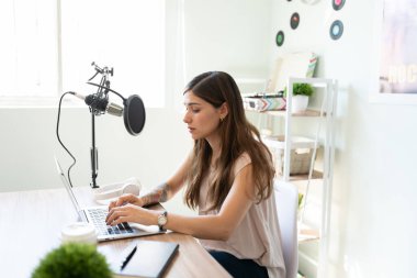 Bir bilgisayar üzerinde çalışan ve podcast 'ini kaydetmeye hazırlanan meşgul bir blogcunun profil görüntüsü