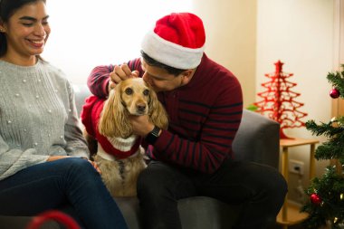 İspanyol çift Noel 'i evde geçiriyorlar, sevimli köpeklerine sarılıyorlar ve Noel kıyafeti giyiyorlar.