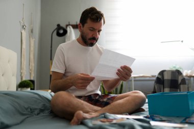 Yalnız bir adam yatakta oturmuş, ilişki bittikten sonra ayrılık mektupları okuyor ve etrafa fotoğraflar saçıyor.