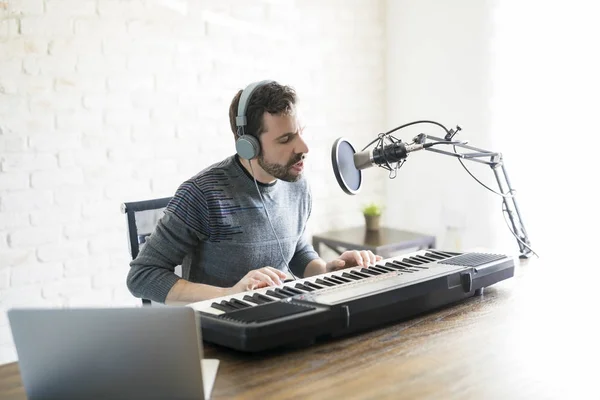 Handsome young latin man playing piano and singing into microphone —  podcast, male - Stock Photo | #197737456