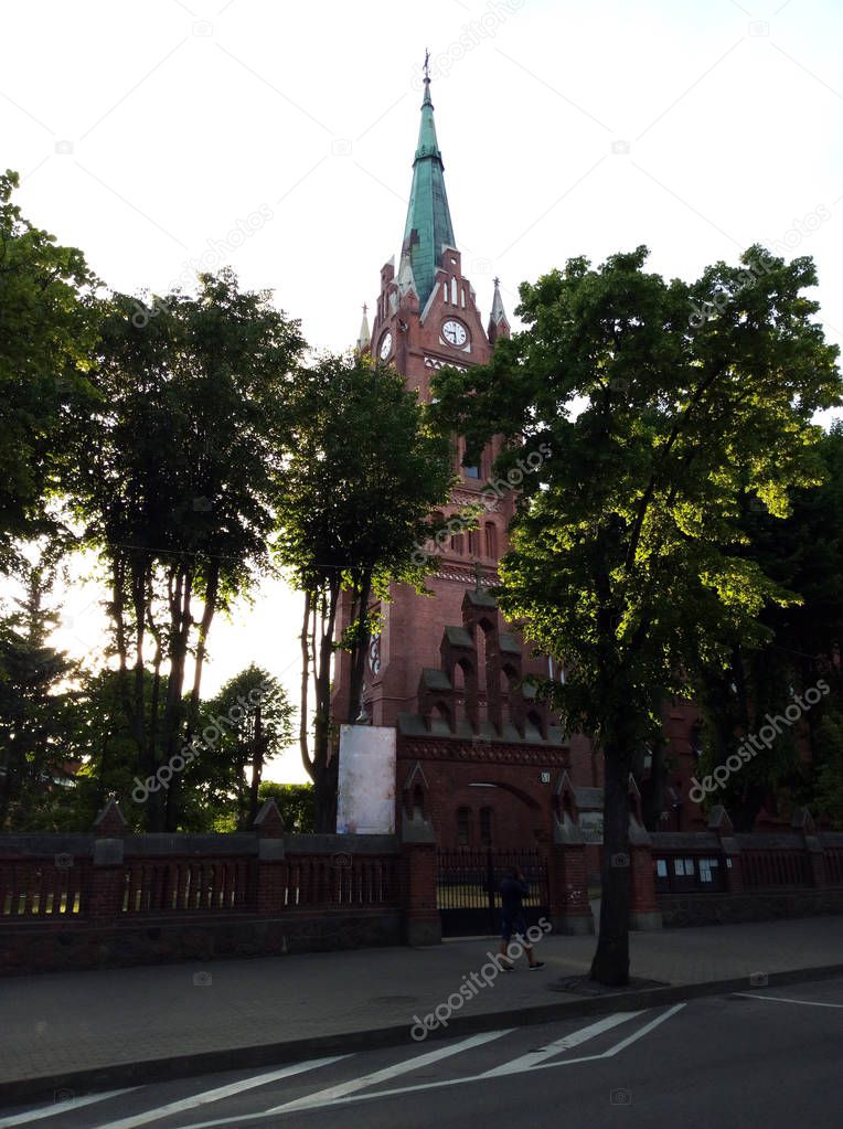 View of the church surrounded by trees on a sunny day.