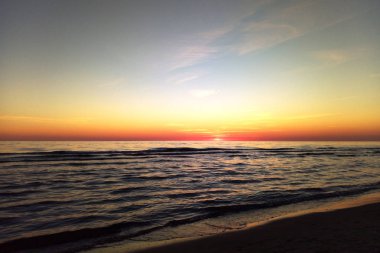 Deniz kenarında güzel renkli gün batımı. Sakin deniz, küçük dalgalar. Baltık Denizi, Palanga, Litvanya