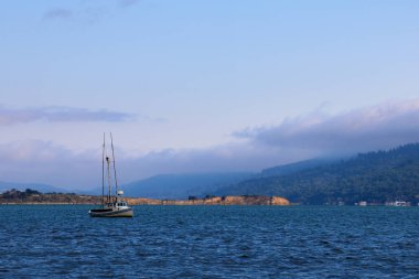Güzel manzara okyanus ve dağ ile küçük yat.