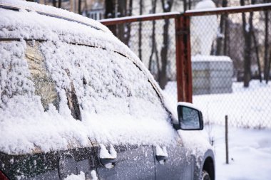 Otoparkta kar arabaları kapladı. Şehir manzarası, kar fırtınası. Kardan temiz otomobil