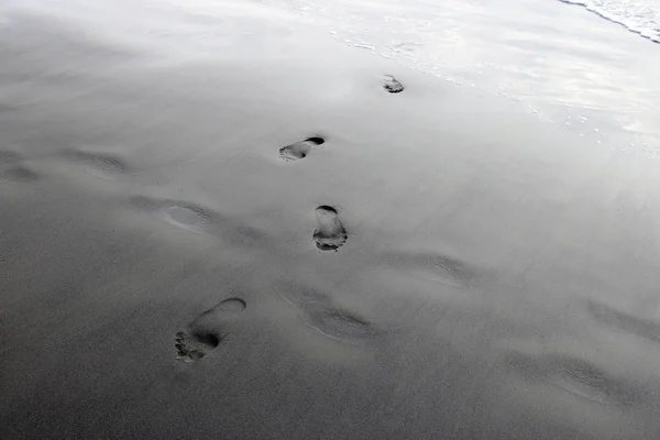 Footprints from the feet of a woman or man on the sand of the beach. — Stock Photo, Image