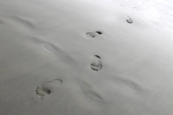 Voetafdrukken van de voeten van een vrouw of man op het strand. — Stockfoto