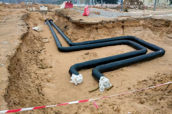 Dağıtım ünitesi ısıtma ağının kurulum süreci. Kum çukurundaki somut bir desteğin borularını bağlamak için çerçeve.