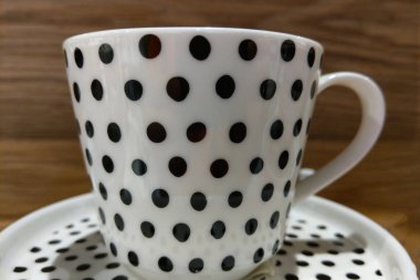 Masanın üzerinde güzel siyah beyaz bir porselen bardak..