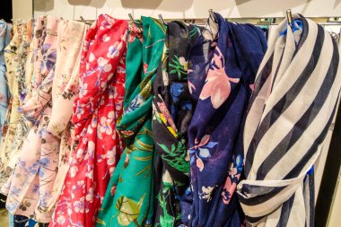 Askıda, arka planda çok renkli güzel eşarplar.