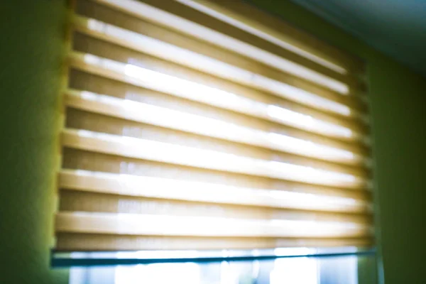 Closeup brown color Roller blinds curtains. sunlight through the windows and roller blind in the city. Soft focus image.