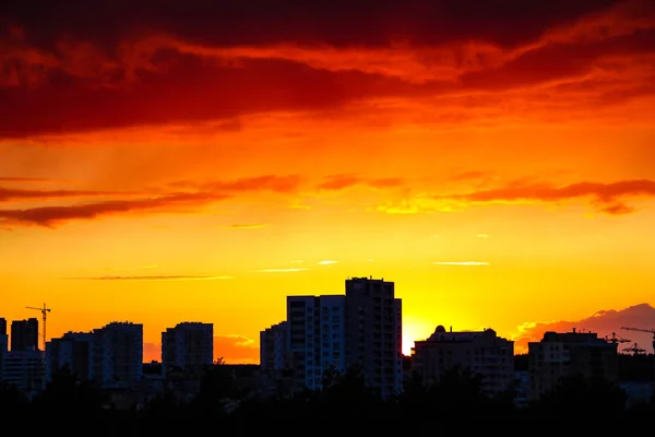 Schöner stürmischer Sonnenuntergang über der Stadt in dramatischen Farben. — Stockfoto