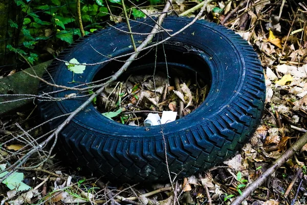 Tekerlekten eski çatlak lastik bir çöplükyatıyor.