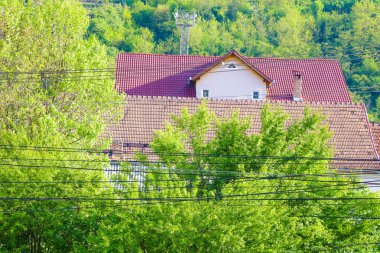 Evin arka planda elektrik telleri çok sayıda ve yeşil tepeler.