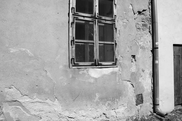 Vista de uma casa velha com rachaduras na parede e janela, foto em preto e branco . — Fotografia de Stock