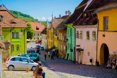 Sighisoara, Romanya, 13 Mayıs 2019: Tipik geleneksel tarzda Sighisoara'da renkli güzel sokak. Eski evler orijinal haliyle korunur. Turistler için popüler hedef.