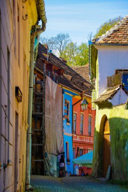 Sighisoara, Romanya, 15 Mayıs 2019: Tipik geleneksel tarzda Sighisoara'da renkli güzel sokak. Eski evler orijinal haliyle korunur. Turistler için popüler hedef.