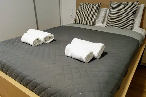 Vista de la cama maquillada con almohadas en el dormitorio con toallas . — Foto de Stock